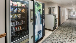 Un couloir avec des distributeurs automatiques et un réfrigérateur.