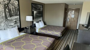 Une chambre d’hôtel avec deux lits, un bureau, une chaise, une télévision et une porte.