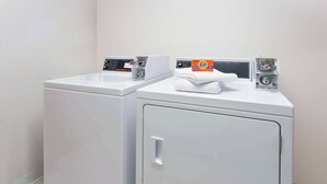 Une buanderie équipée de deux machines à laver et d’un sèche-linge.