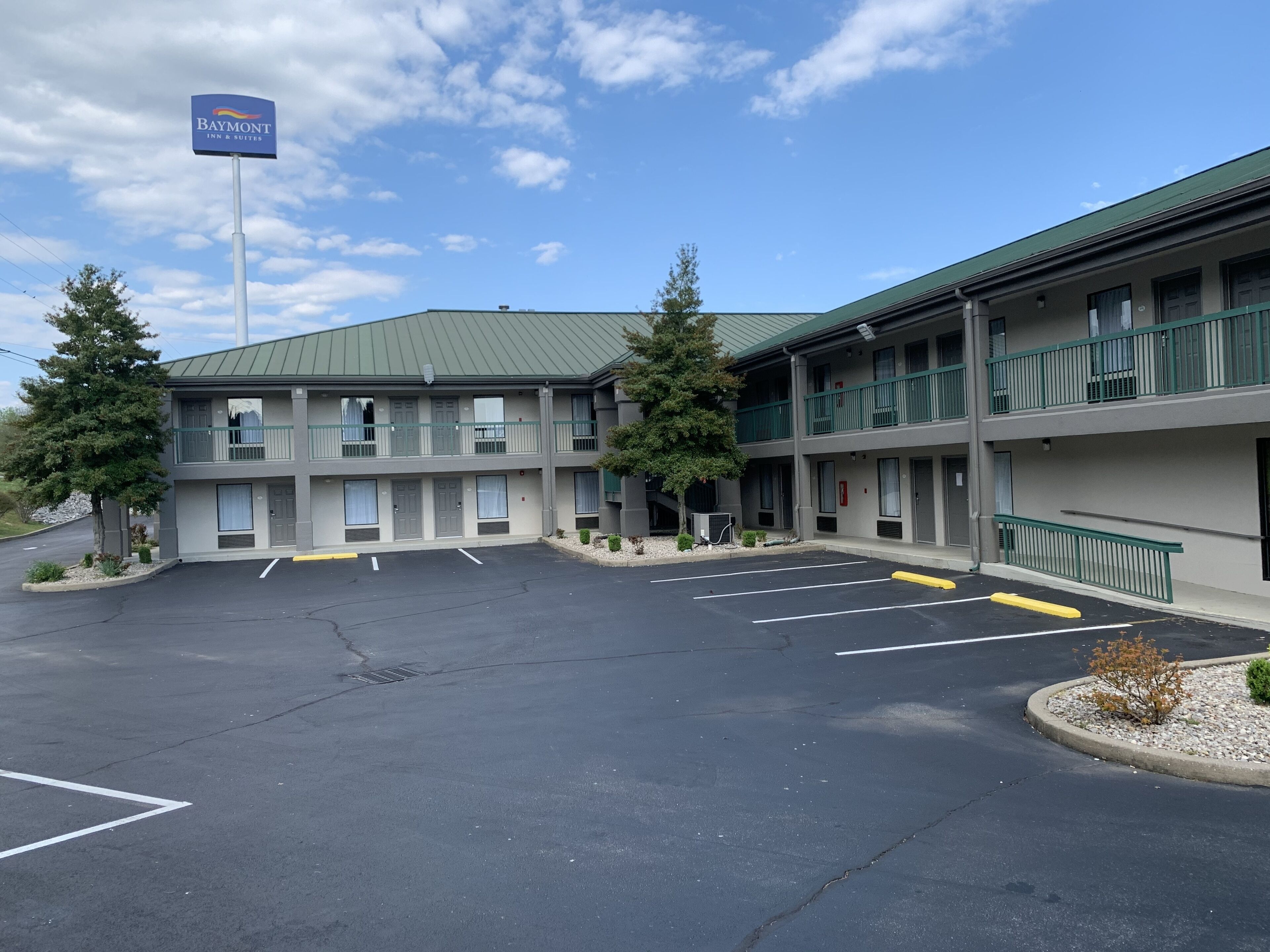 Un hôtel Baymont Inn & Suites, avec un bâtiment à deux étages, un parking et de nombreux arbres.