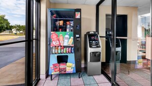 A vending machine with snacks and drinks, an ATM, and a glass door entrance. - Super 8 by Wyndham Columbia (Columbia)