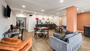 A modern interior with a dining area, a living room with a sofa, and a kitchen area. - Quality Inn Gastonia East (Gastonia)