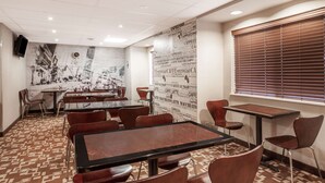 A conference room with tables and chairs, a clock on the wall, and a window with blinds. - Super 8 by Wyndham Schenectady/Albany Area (Schenectady)