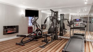 A hotel gym with cardio equipment, weight machines, and a treadmill. - Super 8 by Wyndham Schenectady/Albany Area (Schenectady)