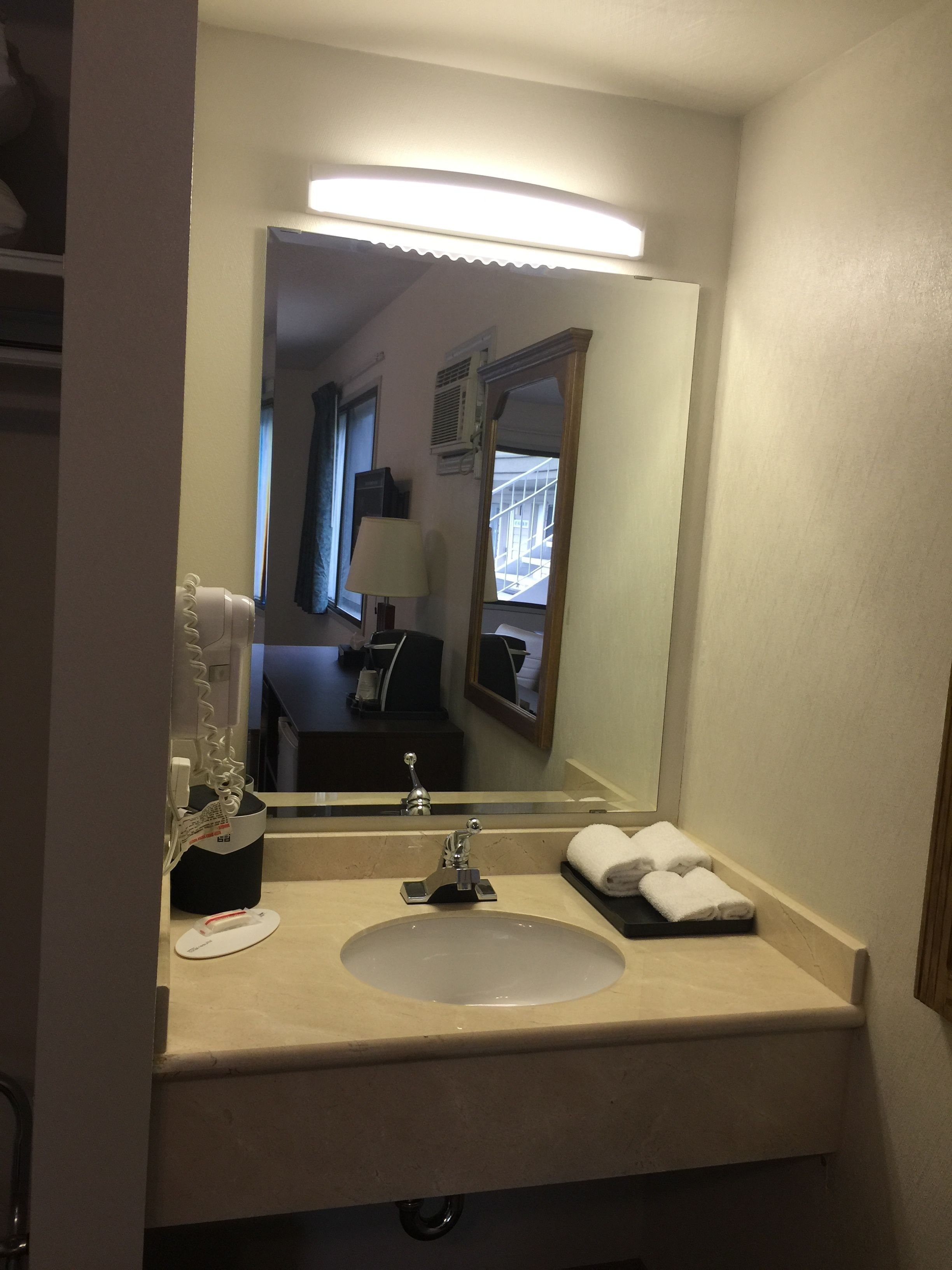 Ein Badezimmer mit Waschbecken, Spiegel und Handtuchhalter.