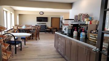 A modern kitchen with wooden cabinets, a built-in stove, and a coffee machine.