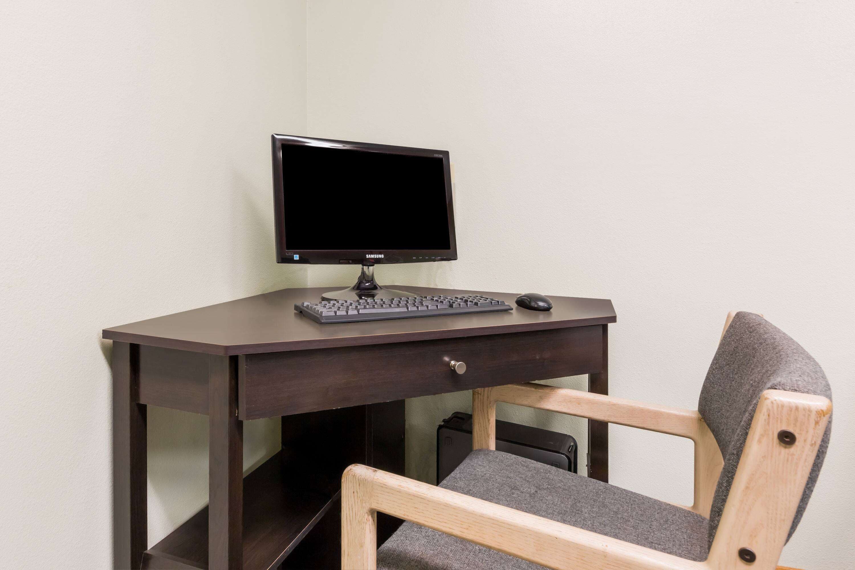 Un bureau d’angle avec un écran d’ordinateur, un clavier et une souris.