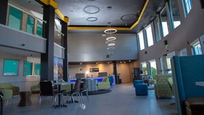 A spacious lobby with a reception desk, seating areas, and large windows.