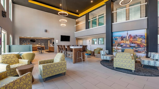 A spacious lobby with a reception desk, seating area, and a large cityscape mural.