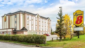 Een hotel met een groot bord waarop 'Super 8' staat, in klassieke bouwstijl.