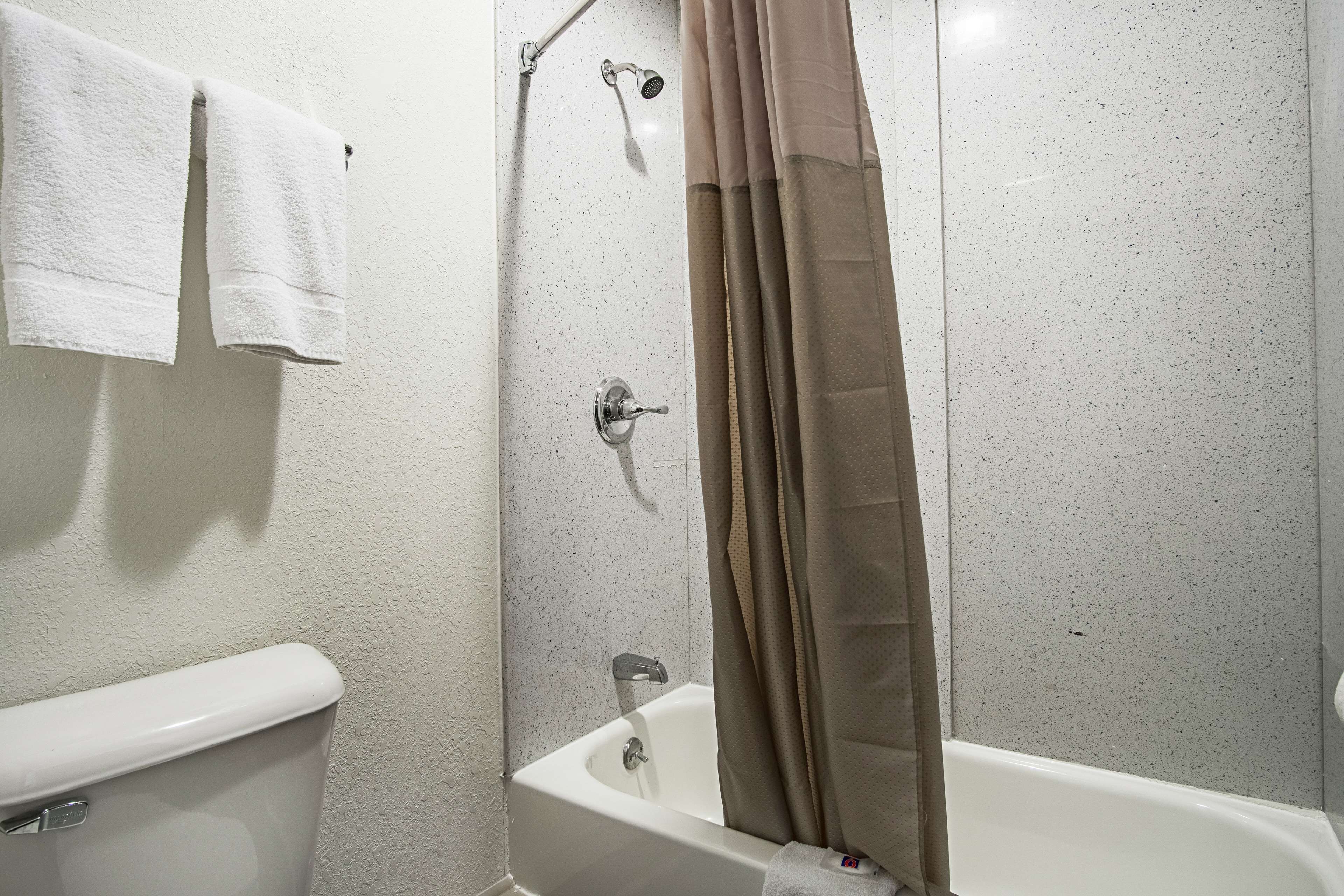 Une salle de bain avec une baignoire, un rideau de douche et des toilettes.