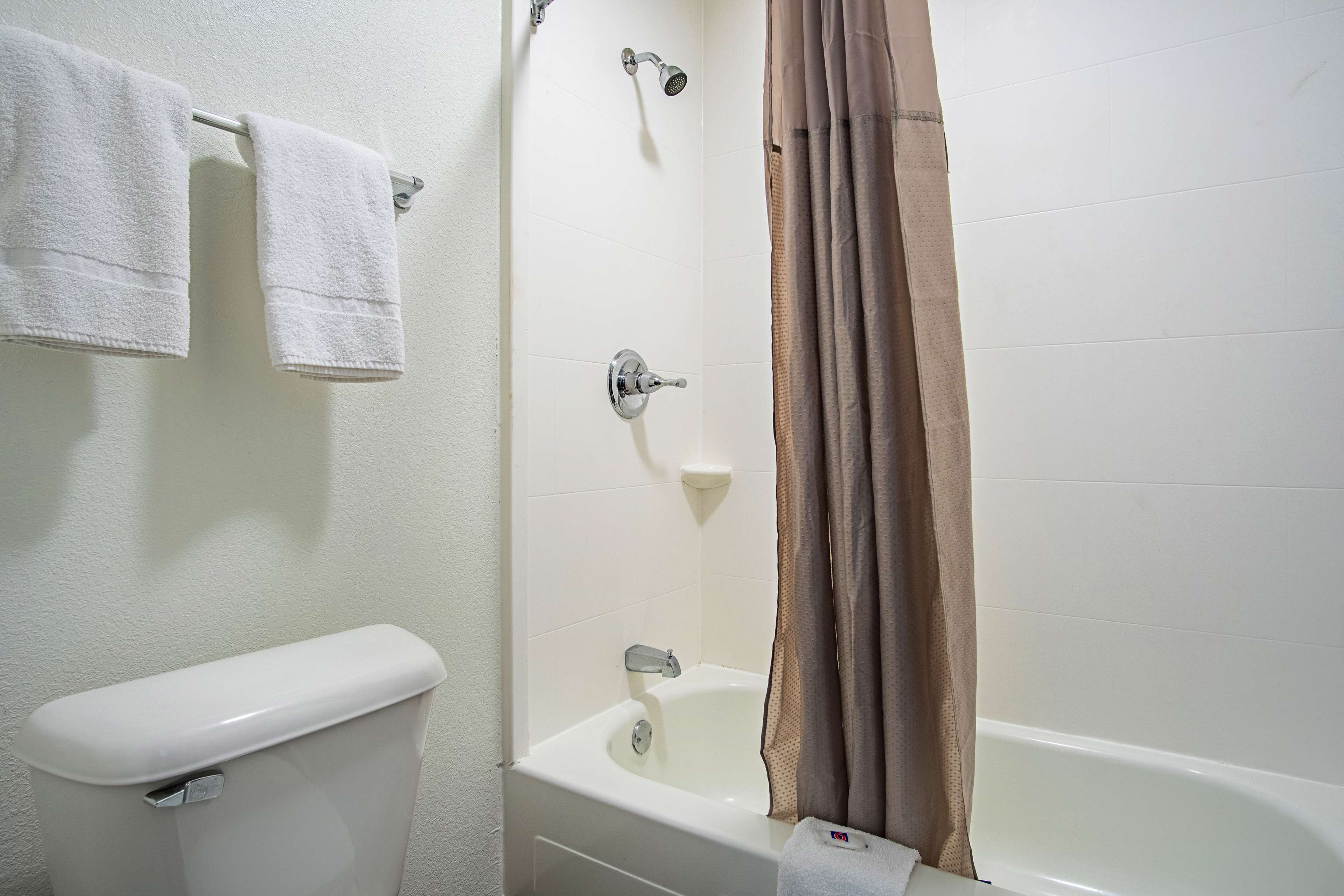Une salle de bain comprenant des toilettes, une baignoire et une douche.