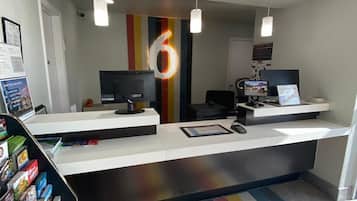 A reception area with a counter, computers, and a colorful striped floor.