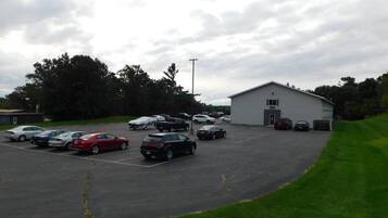 A parking lot with several cars and a building with a flat roof.