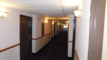 Et hotel med døre, lysarmaturer og et tæppe på gulvet.