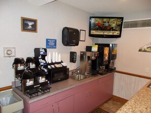 A hotel kitchen with coffee machines, a microwave, and a coffee dispenser. - Northwoods Best Inn - Chetek (Chetek)