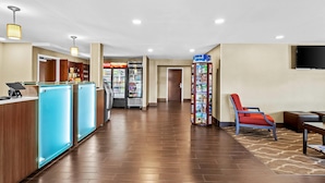 A hotel lobby with a reception desk, vending machines, a seating area, and a staircase leading to the upper floors. - Comfort Inn Chambersburg North (Chambersburg)