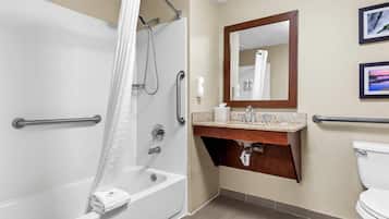 A modern bathroom with a walk-in shower, grab bars, a vanity with a mirror, and a toilet.