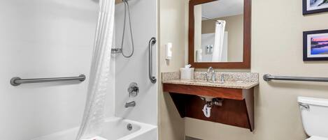 A modern bathroom with a walk-in shower, grab bars, a vanity with a mirror, and a toilet.