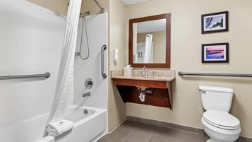 Un baño con bañera, lavamanos con espejo e inodoro.