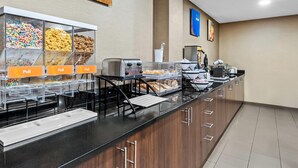 A buffet setup with cereal and granola options, a coffee station, and a microwave. - Comfort Inn Chambersburg North (Chambersburg)