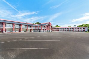 A Red Roof Inn with a large parking lot and a clear blue sky. - Red Roof Inn Berea (Berea)