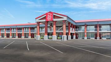 A Red Roof Inn with a central entrance, multiple balconies, and a parking lot.