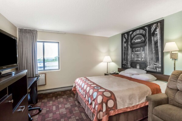 A hotel room with a bed, a TV, a desk, a chair, a window, and a painting on the wall. - Super 8 by Wyndham Luverne (Luverne)