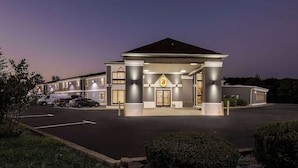 A hotel with a prominent entrance, a parking lot, and a well-lit facade. - Super 8 by Wyndham Dickson (Dickson)