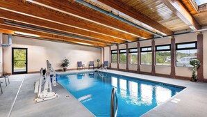 An indoor swimming pool with wooden beams, clear windows, and a lifeguard stand. - Super 8 by Wyndham Dickson (Dickson)
