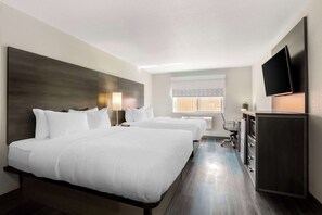A hotel room with two beds, a flat-screen TV, a desk with a chair, and a minibar. - Clarion Pointe Prescott Valley (Prescott Valley)