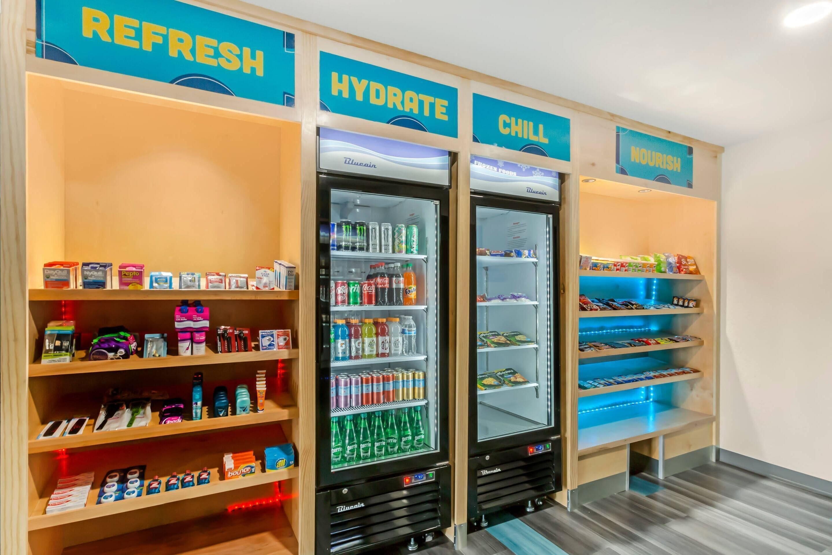 A vending area with labeled sections for refreshments, hydration, and nourishment, featuring various drinks and snacks.