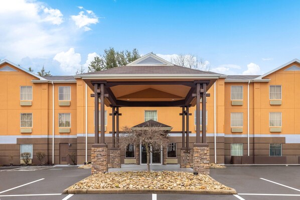 Un hôtel doté d’une entrée abritée, d’un parking et offrant une vue sur un ciel dégagé.