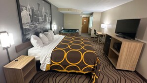 A hotel room with a bed, a desk, a television, and a cityscape painting on the wall. - Super 8 by Wyndham Mars/Cranberry/Pittsburgh Area (Mars)