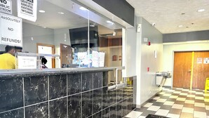 A reception area with a check-in counter, a no public restroom sign, and a no refunds policy sign. -  Kings Inn By OYO Calumet Park I-57 (Calumet Park)