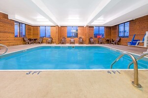 Una piscina interior con paredes de madera y ventanas amplias.