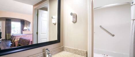 A bathroom with a sink, mirror, toilet, and shower.