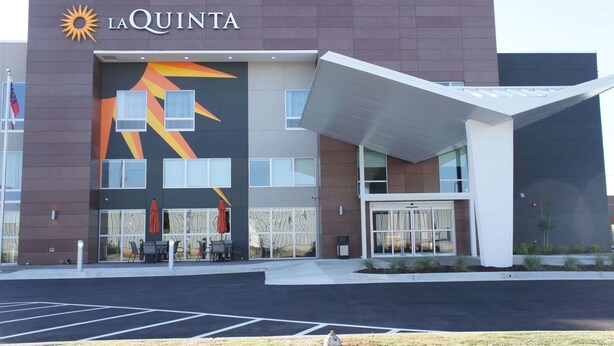 A La Quinta hotel with a modern facade, large windows, and a covered entrance area.