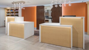Un espace d’accueil au design moderne, comprenant un comptoir, un coin salon et une étagère où sont exposés des produits.