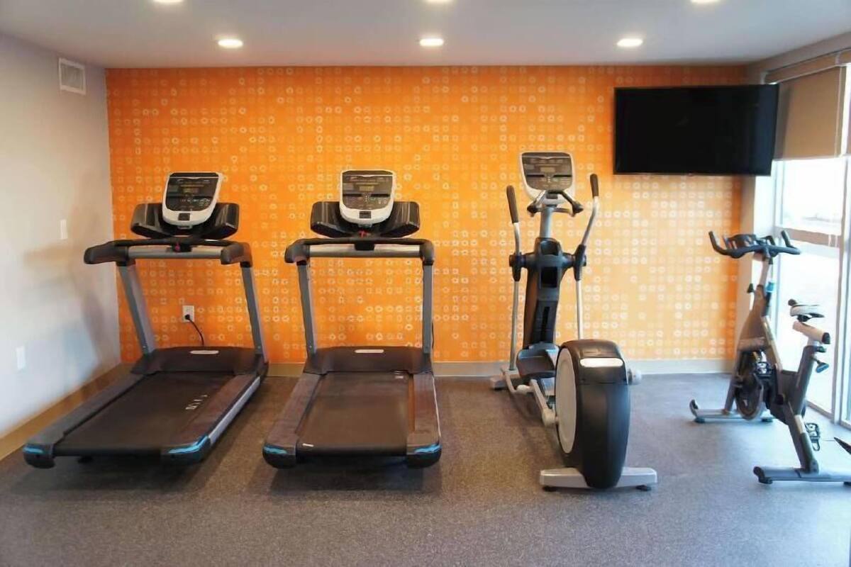 A gym with treadmills, an elliptical, and a stationary bike.