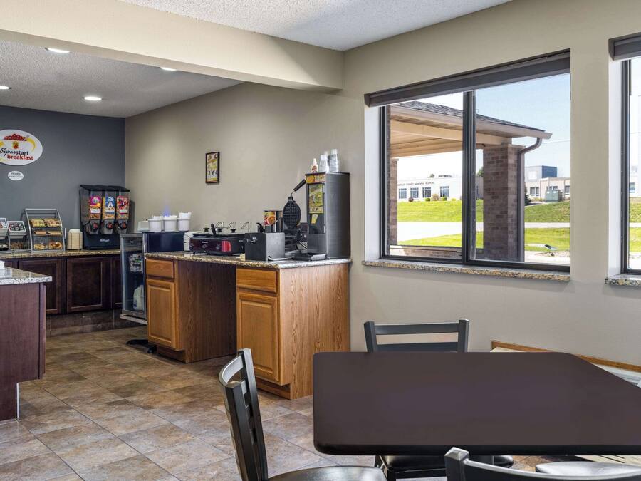 A breakfast area with a counter, seating, and a view of the outdoors.