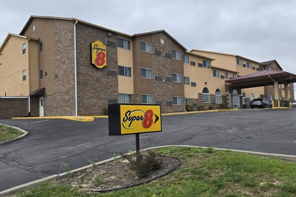 Un hotel Super 8 con un letrero llamativo, un estacionamiento y una entrada cubierta.