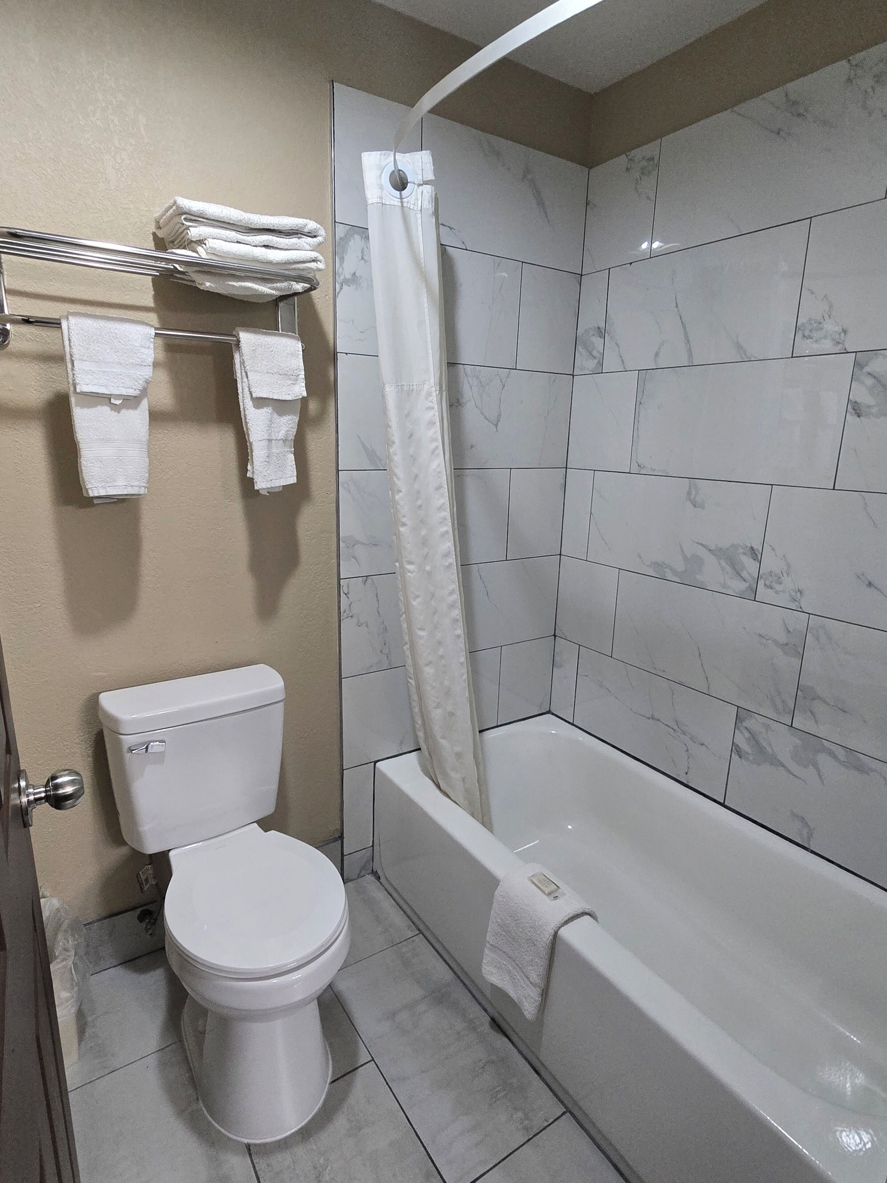 A bathroom with a toilet, a bathtub, and a shower curtain.