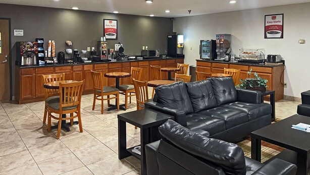 A modern cafe with wooden furniture, a black leather sofa, and a coffee machine. - Econo Lodge Chillicothe (Chillicothe)