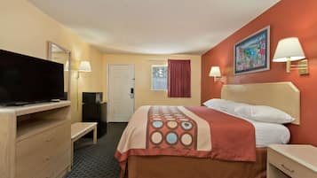 A hotel room with a bed, a TV, a desk, and a chair.