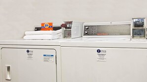 A front-loading washing machine with Tide detergent and a Speed Queen commercial washer. - Super 8 by Wyndham Chipley (Chipley)