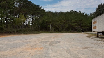 A gravel parking area with a building on the right.