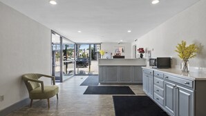 A modern kitchen with grey cabinetry, a black countertop, and a vase with yellow flowers. - The Inn on Arsenal (Watertown)