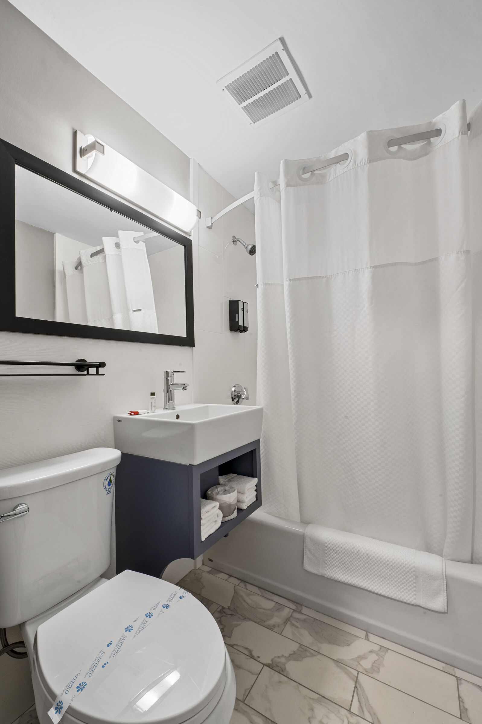 A modern bathroom with a toilet, sink, and shower area.