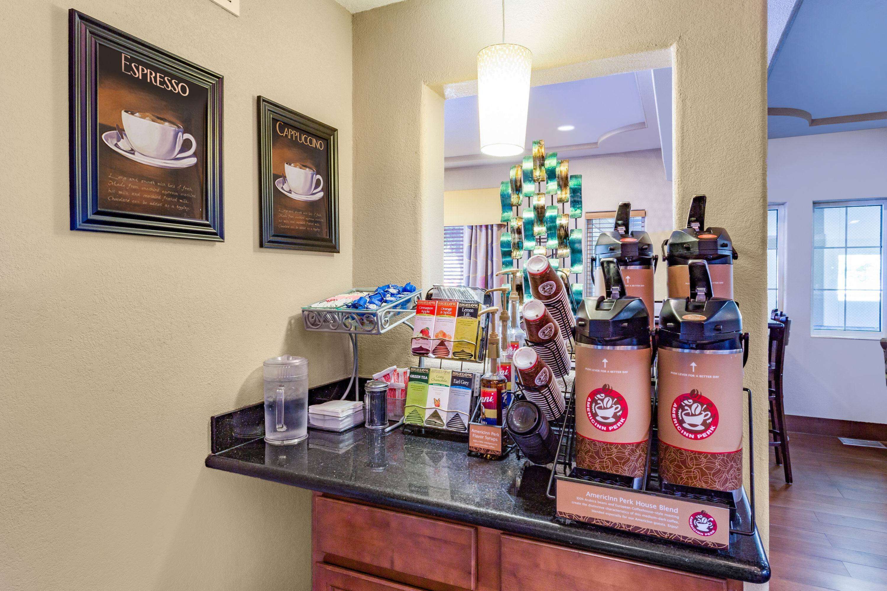 A coffee station with espresso and cappuccino options, a coffee maker, and a display of coffee bags.